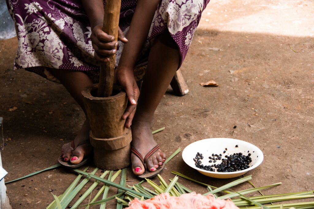 Zubereitung Von Kenias Nationalgericht: Ugali. Der Mais Wird Zerkleinert Zu Maismehl